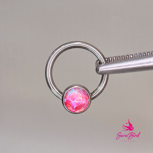 Aro cautivo de titanio con ópalo sintético rosa fluorescente extraíble
